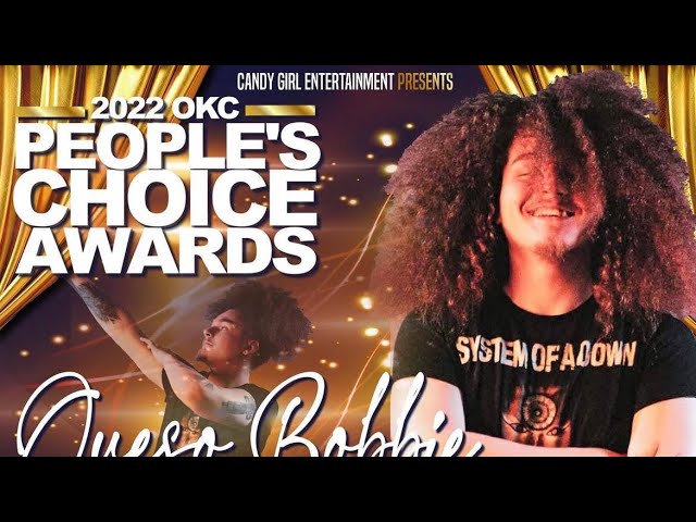 Queso Bobbie smiling with long curly hair on his 2022 OKC People’s Choice Awards performance card