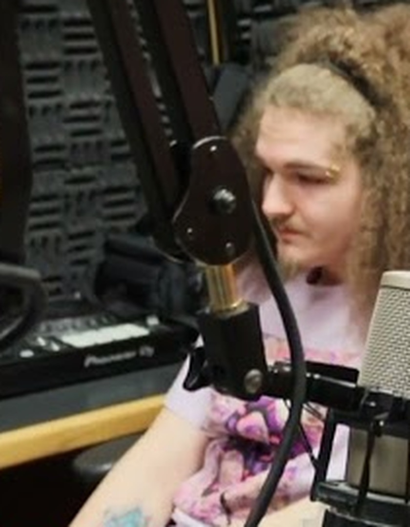 Queso Bobbie seated behind a studio microphone during a Pirate Ship Radio interview