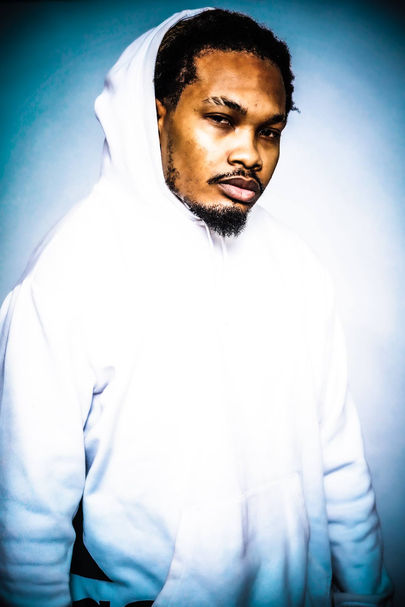 Indigo Kirk3 wearing a white hooded top in an artist-supplied editorial portrait. Photograph by Echo The Savage.