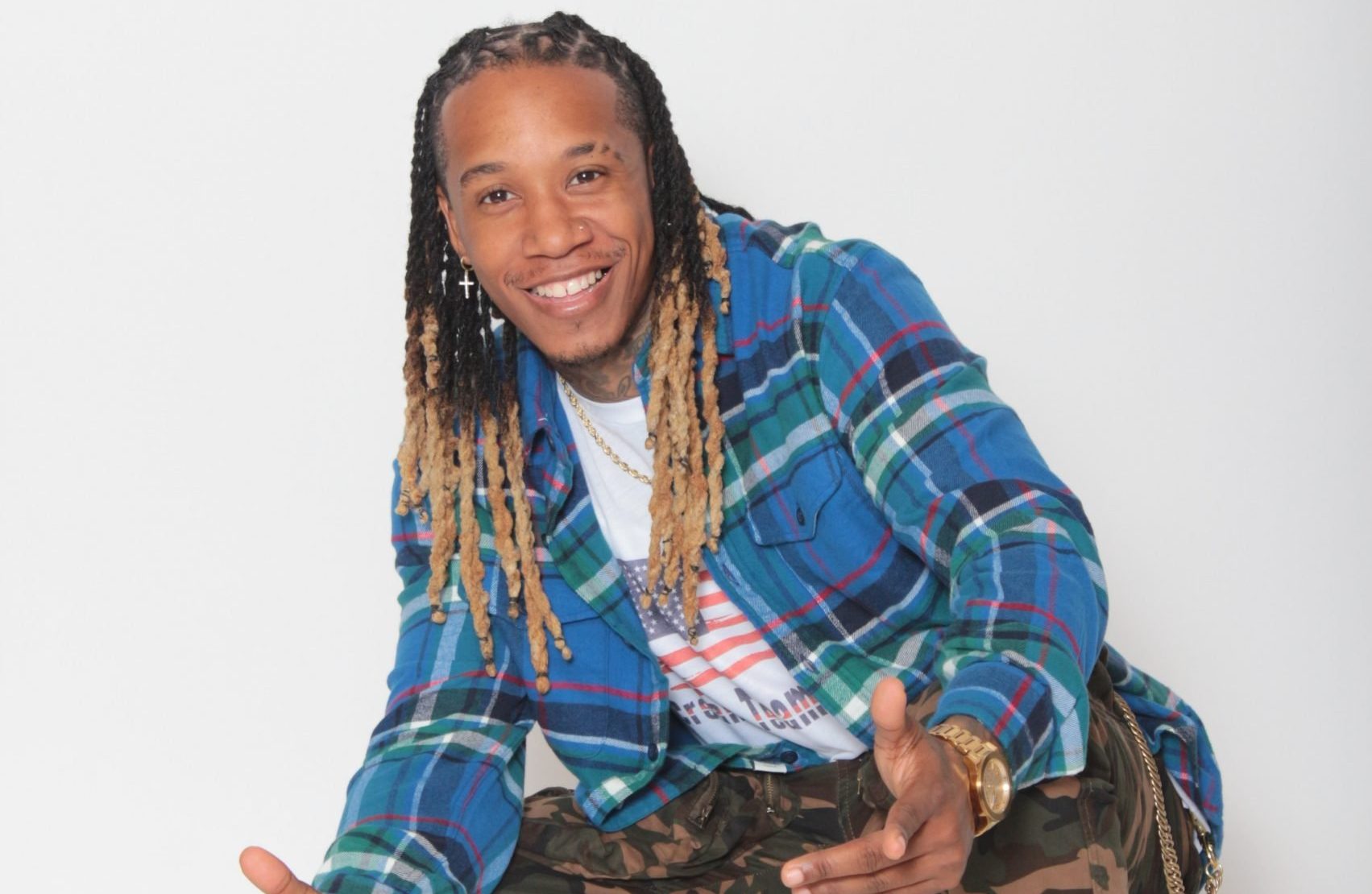 Starr Lyfe smiling in a blue plaid shirt against a light background